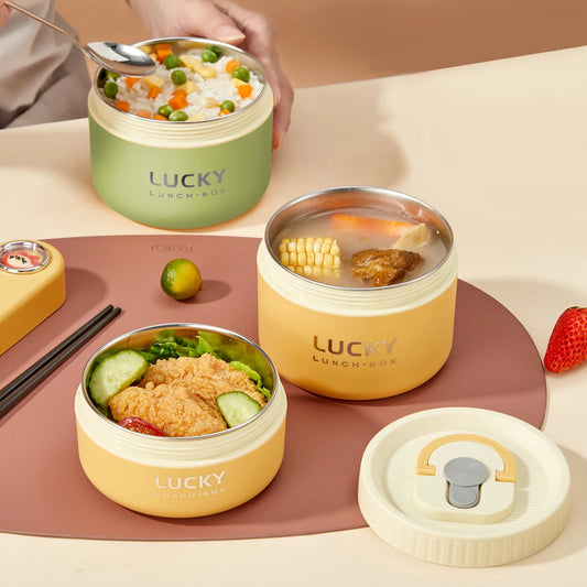 Three 'LUCKY' lunch boxes with different contents on a table.