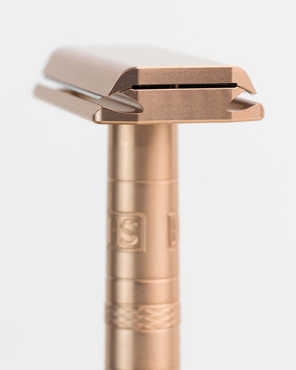 Rose gold safety razor on a white background